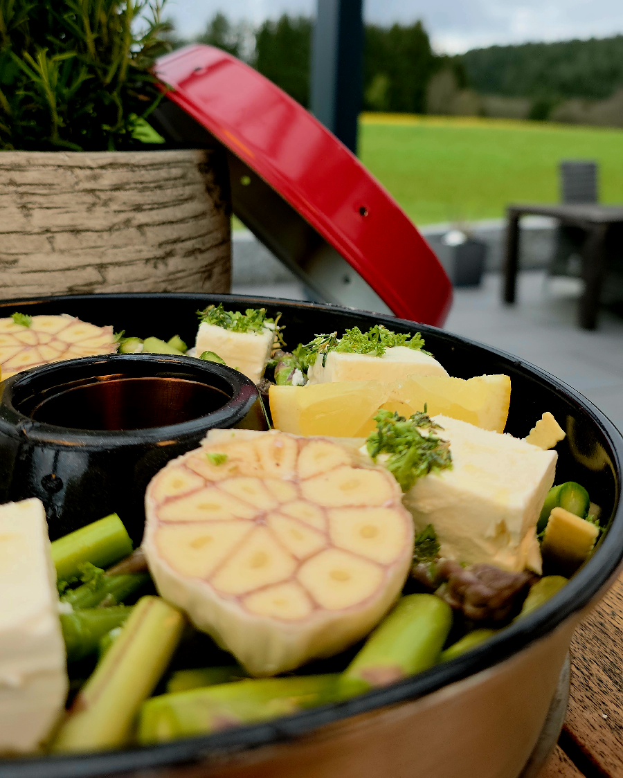 Nahaufnahme eines Nudelgerichts mit Spargel und einer cremigen Soße, das dampfend aus dem Omnia Campingbackofen kommt.