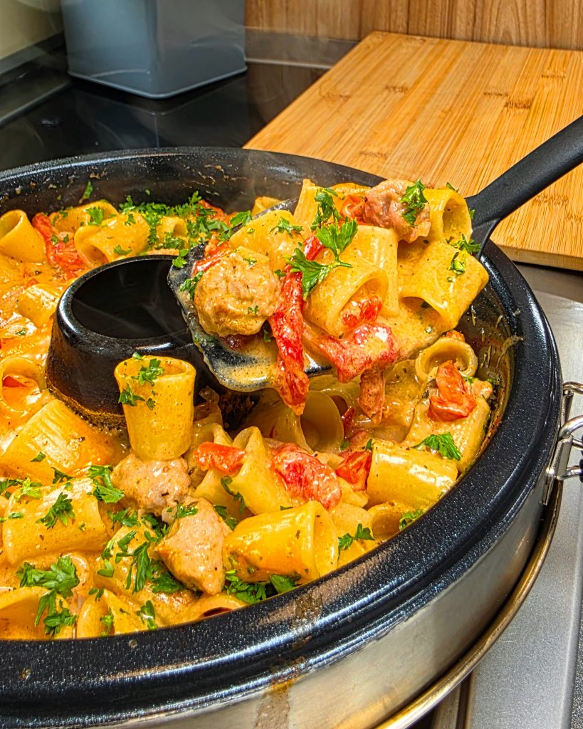 Deftige Bratwurst Pasta mit Tomatensauce und Käse im Petromax Campingbackofen zubereitet.