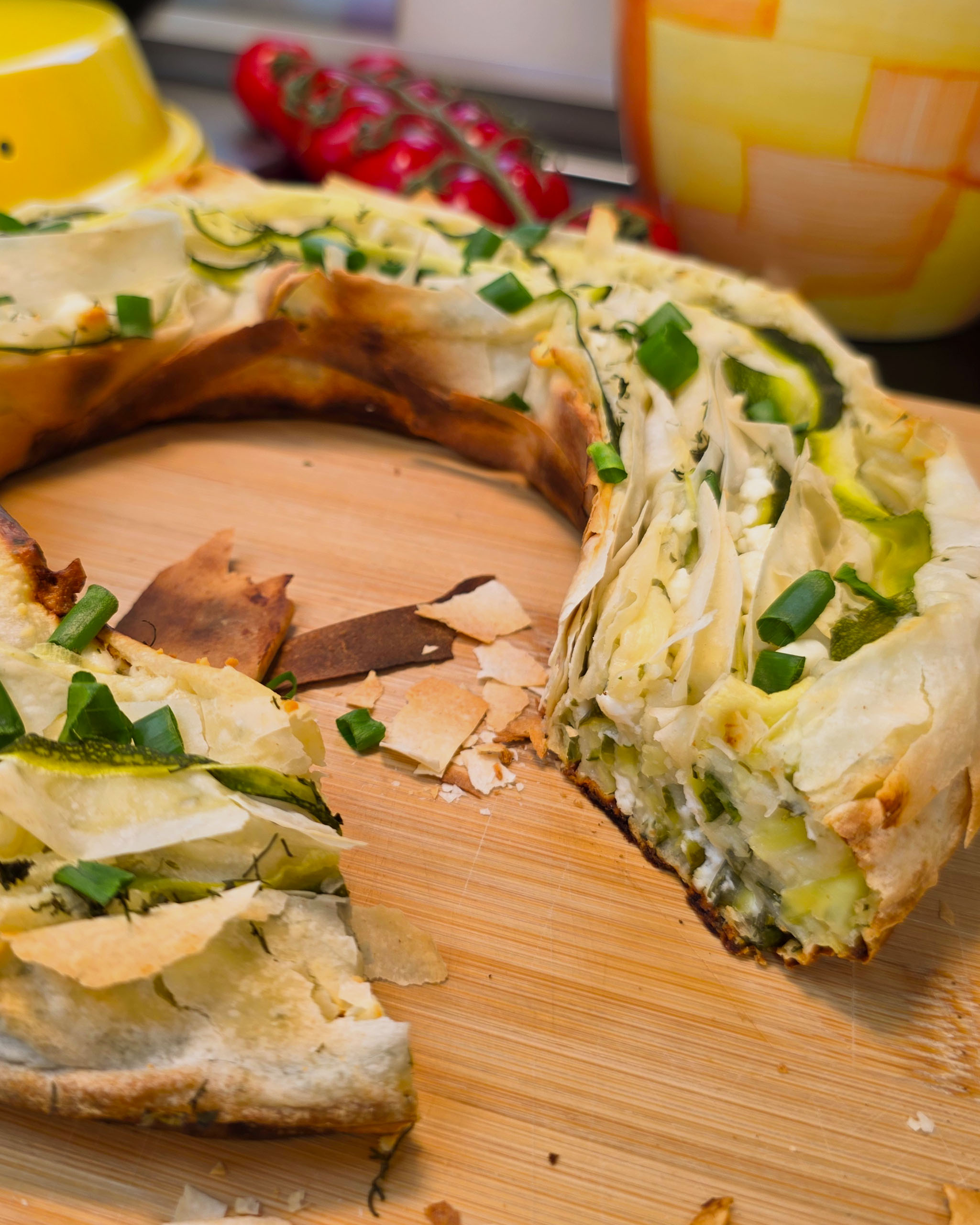 Nahaufnahme einer Portion knusprigen Böreks mit sichtbarer Zucchini-Feta-Füllung und Sesam-Topping, frisch aus dem Omnia Campingbackofen.