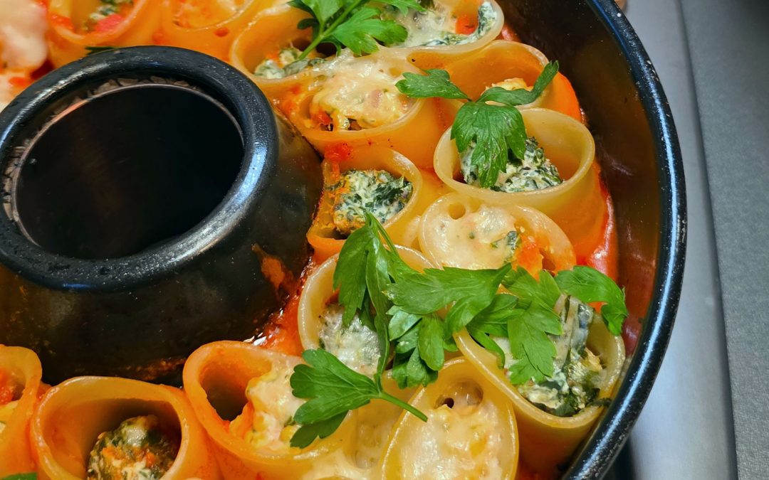 Ringförmig angeordnete Cannelloni mit Ricotta-Spinat-Füllung und Käsekruste im Omnia Campingbackofen.