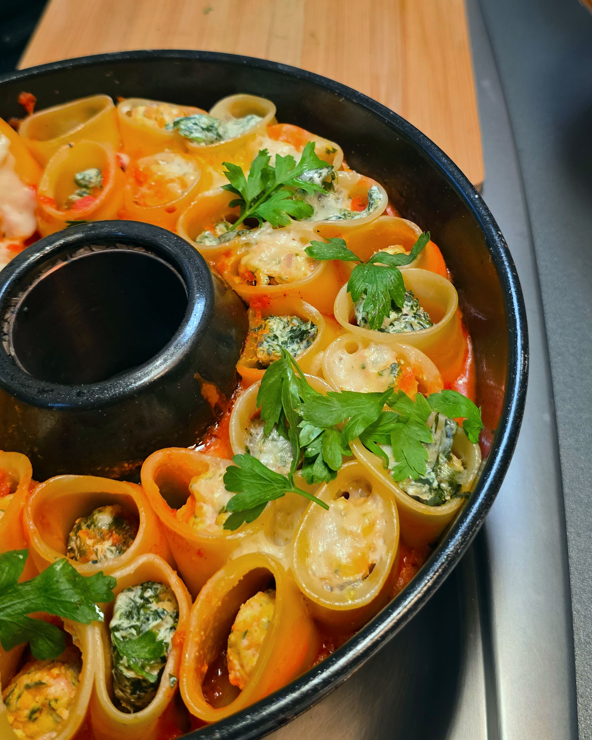 Ringförmig angeordnete Cannelloni mit Ricotta-Spinat-Füllung und Käsekruste im Omnia Campingbackofen.