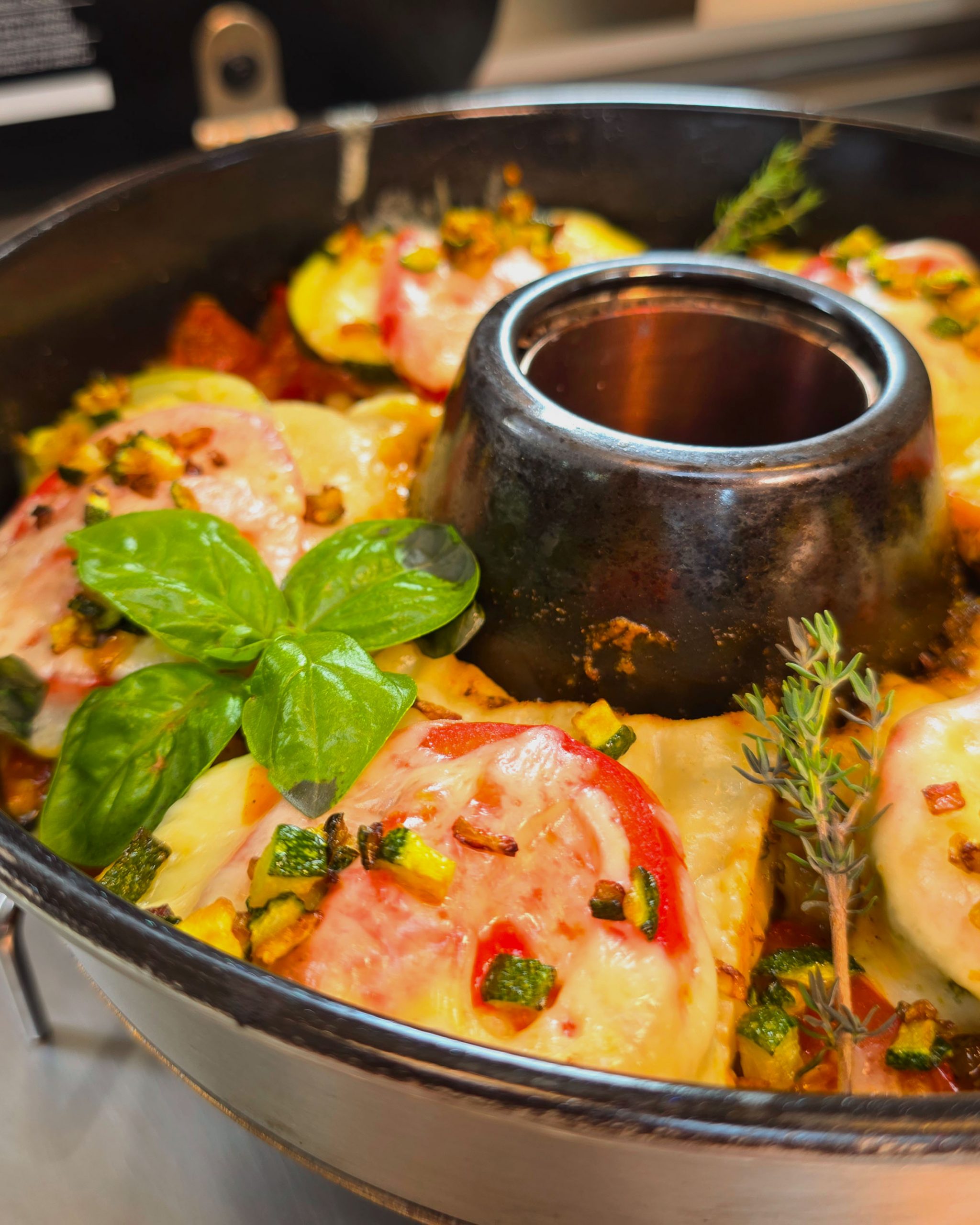 Geschichtete Maultaschen mit Zucchini, Tomaten und geschmolzenem Mozzarella im eckigen Roadbaker Campingbackofen.