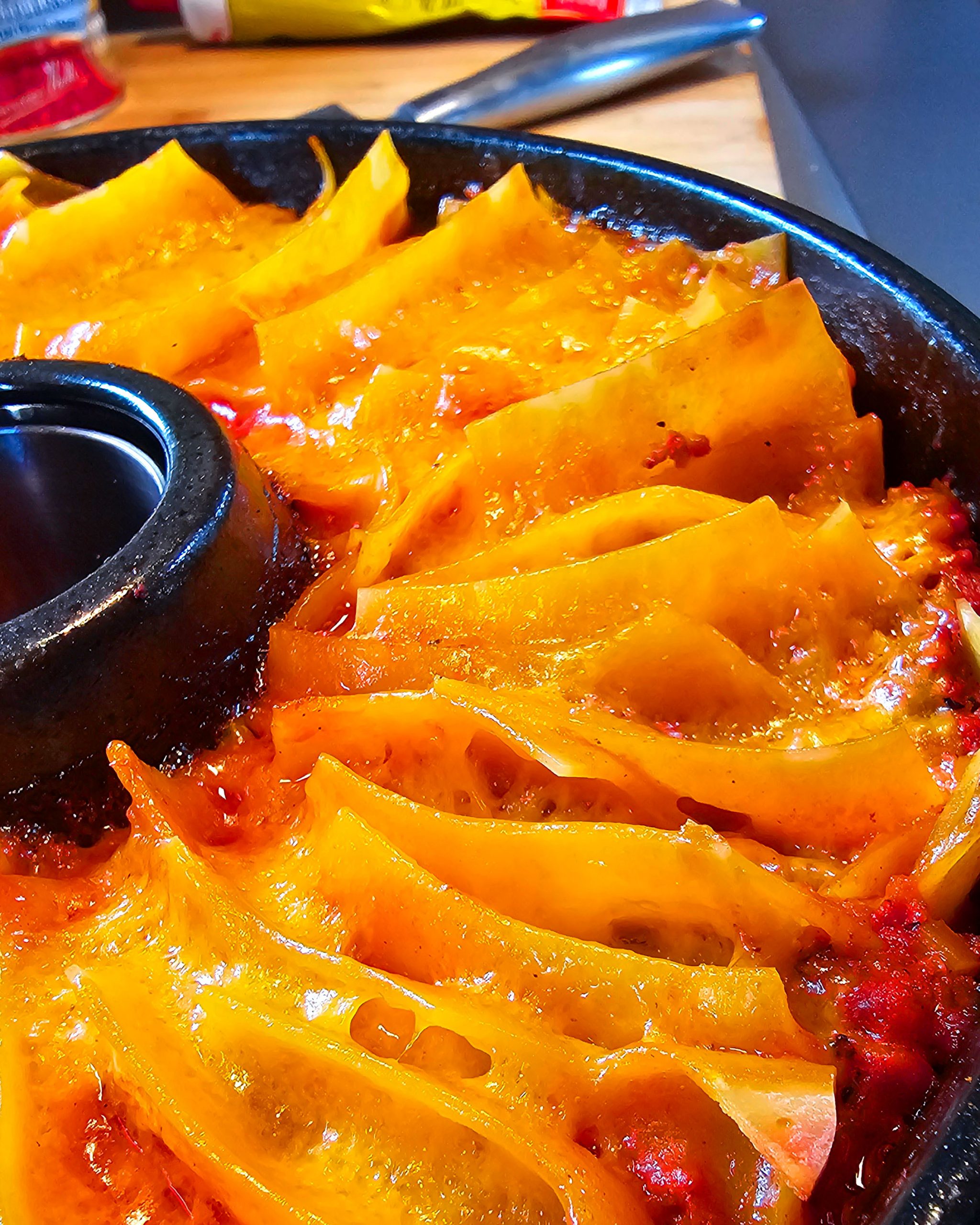 Nahaufnahme eines Nudelgerichts mit Hackfleischsoße, Käse und Lasagneplatten, das dampfend aus dem Omnia Campingbackofen kommt.