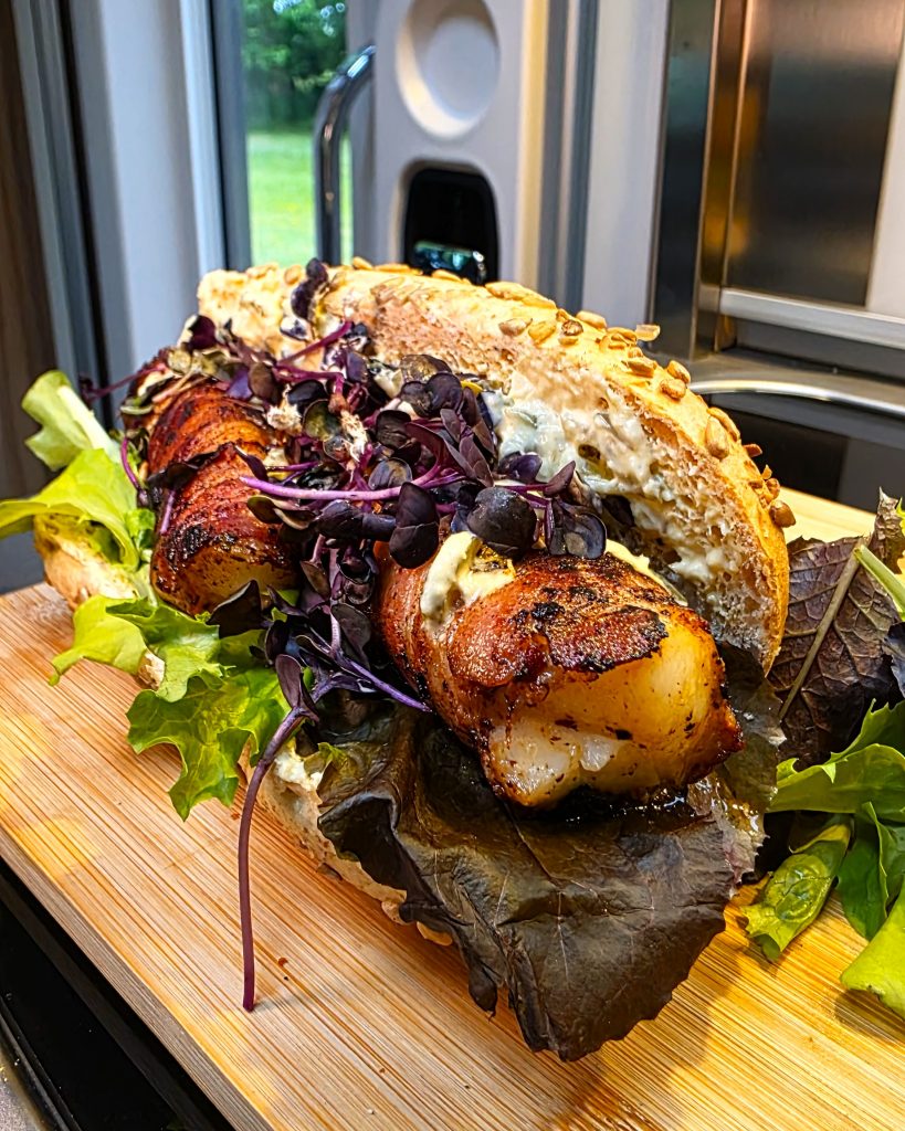 Knuspriger Fischdog mit selbstgemachter Remoulade im Hotdog-Brötchen, serviert am Nordsee-Stellplatz.