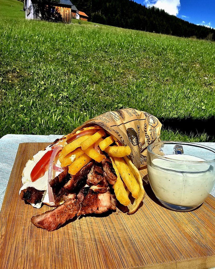 Gyros Grill Fertiger Gyros mit knusprigen Pommes frites, Tzatziki und Zwiebeln, zubereitet im Big Green Egg Grill.