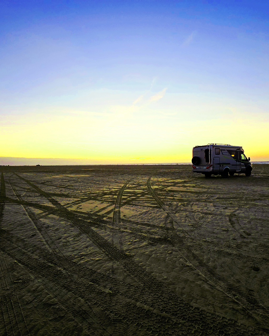 Weißes Wohnmobil parkt auf dem riesigen Sandstrand von Lakolk auf Rømø im dänischen Winter.