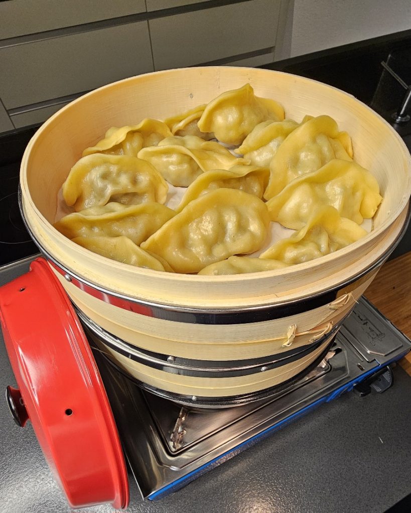 Gedämpfte asiatische Dumplings mit Dip, zubereitet im Omnia Campingbackofen.