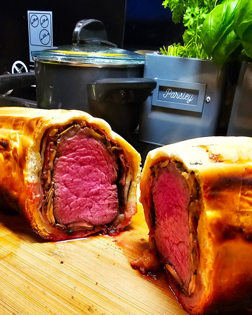 Rosa gegartes Beef Wellington im knusprigen Blätterteigmantel, zubereitet im Omnia Campingbackofen.