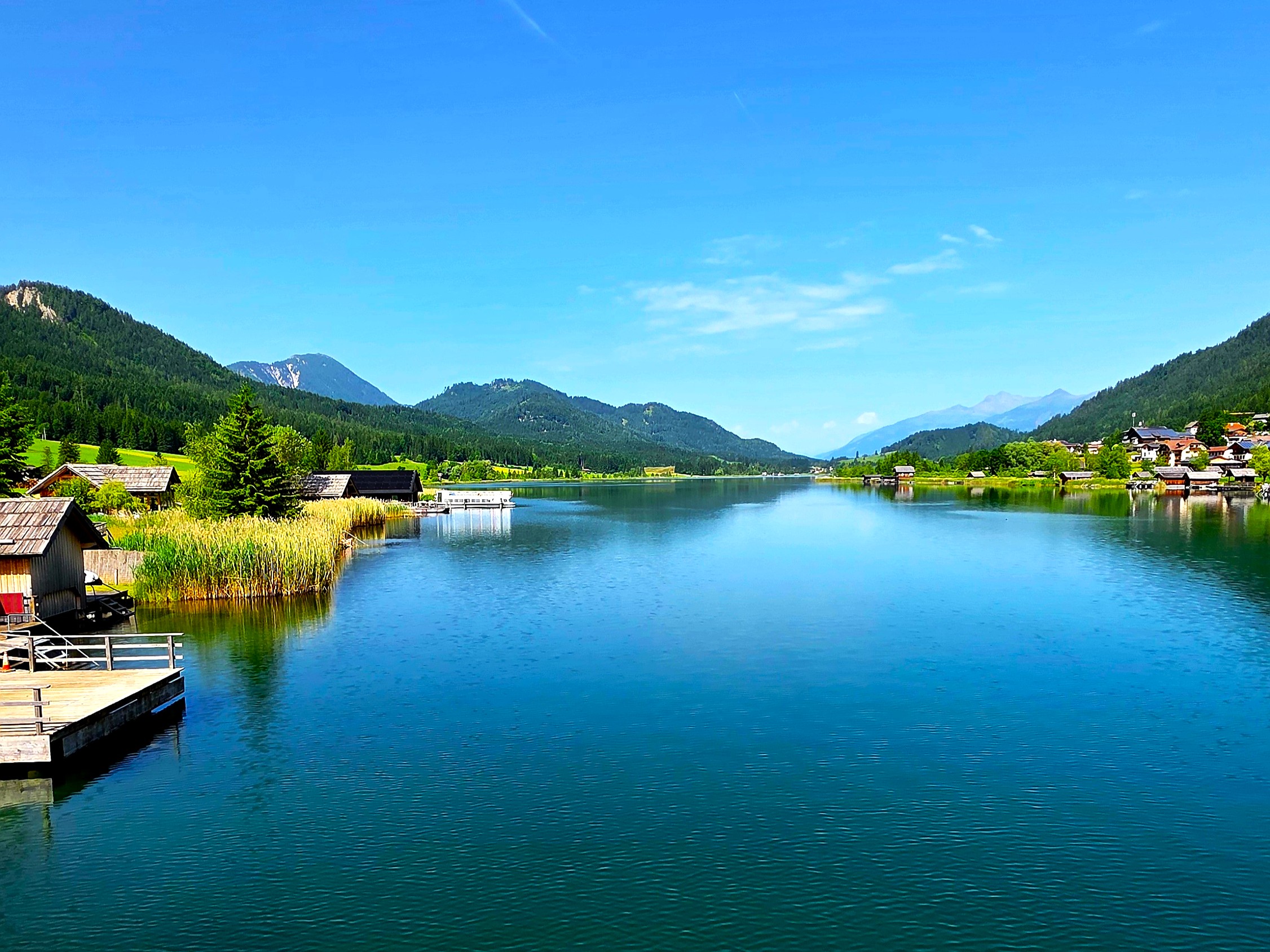 Wohnmobil auf dem Campingplatz am klaren Weissensee in Kärnten umgeben von Bergen.