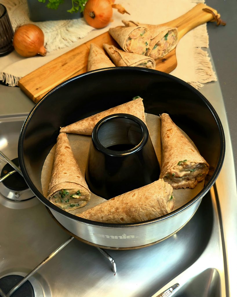 Frisch gebackenes Hörnchen im Campingbackofen auf perfekt zugeschnittenem Backpapier.