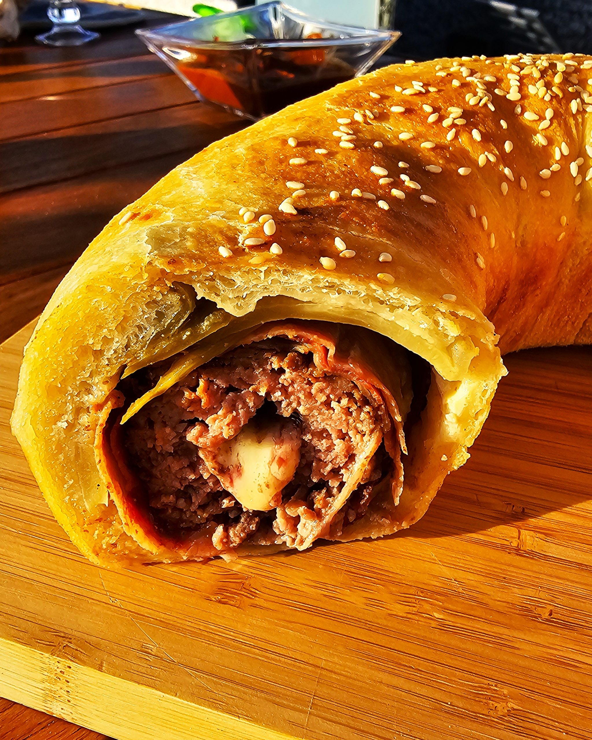 Herzhafter Donut Burger aus Hefeteig, gefüllt mit Rinderhack, Speck und Käse im Omnia Campingbackofen.