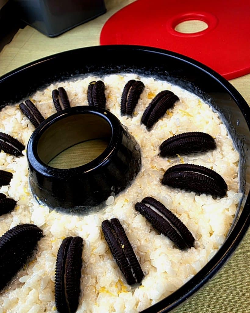 Cremiger Milchreis mit hochkant eingesteckten Oreo Keksen in der Omnia Form.