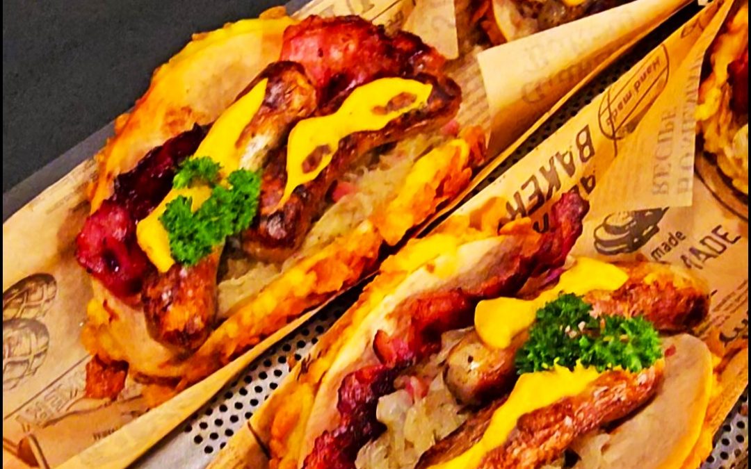 Crispy Tortilla Wrap gefüllt mit Nürnberger Würstchen, Sauerkraut, Kartoffelbrei und Cornflakes-Panade.