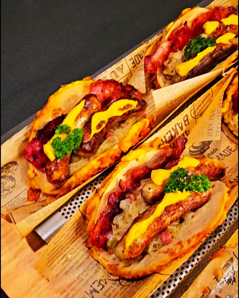 Crispy Tortilla Wrap gefüllt mit Nürnberger Würstchen, Sauerkraut, Kartoffelbrei und Cornflakes-Panade.