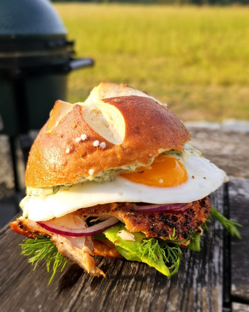 pulled-lachs-burger-big-green-egg-minimax Saftig zerzupfter Pulled Lachs im Burger-Bun, frisch zubereitet auf dem Big Green Egg MiniMax Keramikgrill