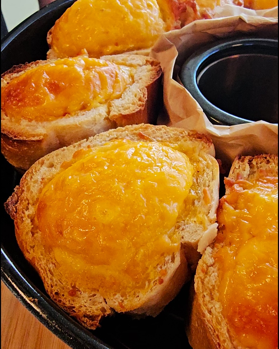 Ausgehöhlte Brötchen gefüllt mit Rührei, Lachs und Schinken im Omnia Campingbackofen.