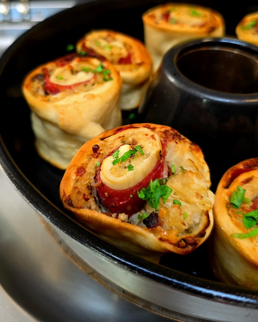 Goldbraun gebackene Sauerkrautschnecken mit Speck und Käse in der Omnia Silikonform.