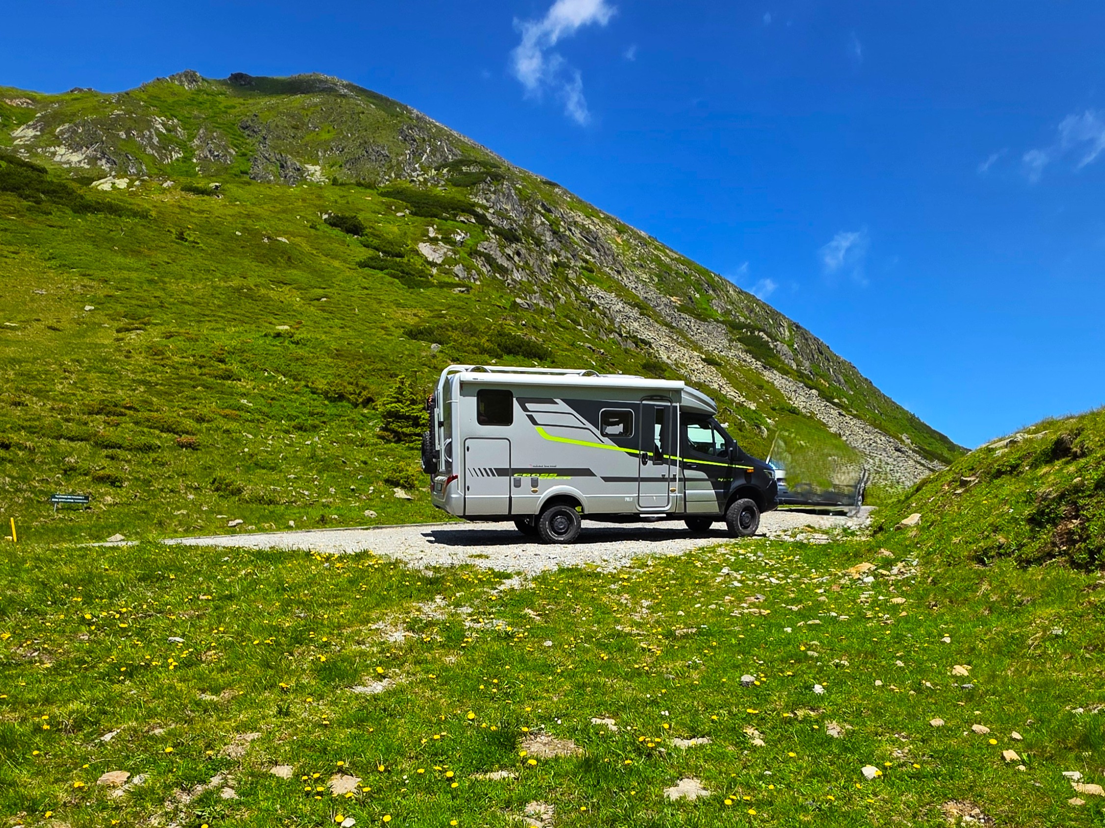 Wohnmobil auf der Passhöhe des Sölkpass in der Steiermark mit Blick auf die Alpenwelt.