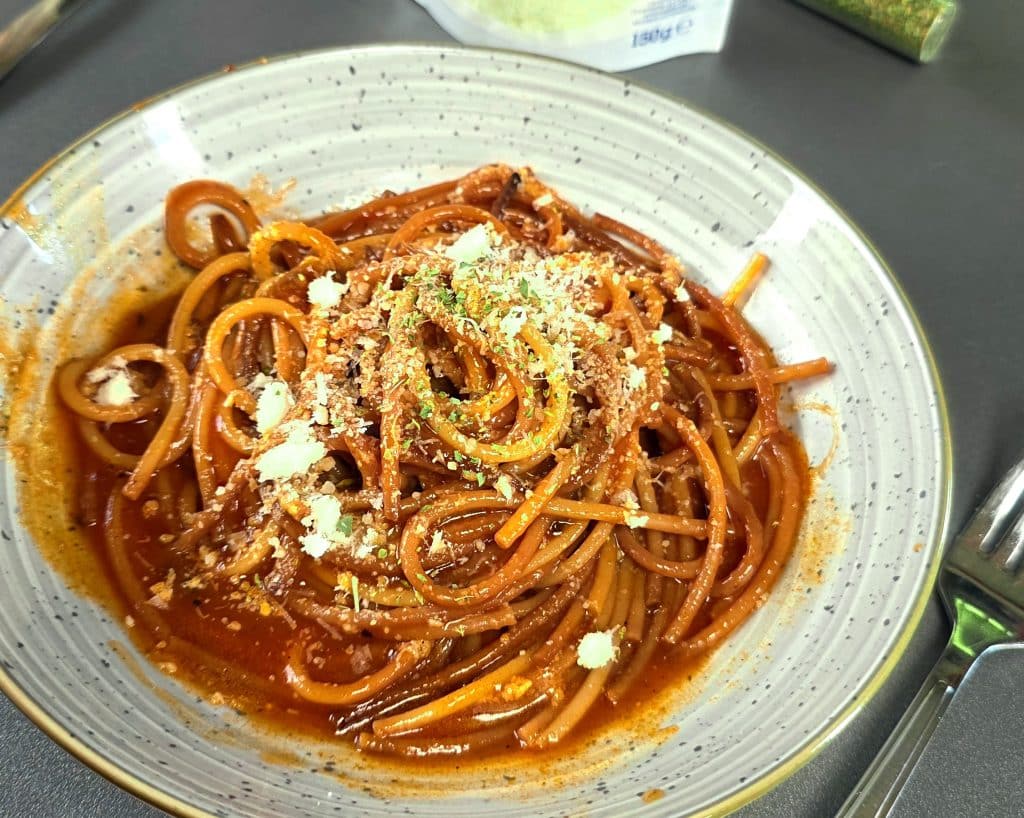 Spaghetti all’Assassina mit Tomatensoße und Parmesan in einer Pfanne