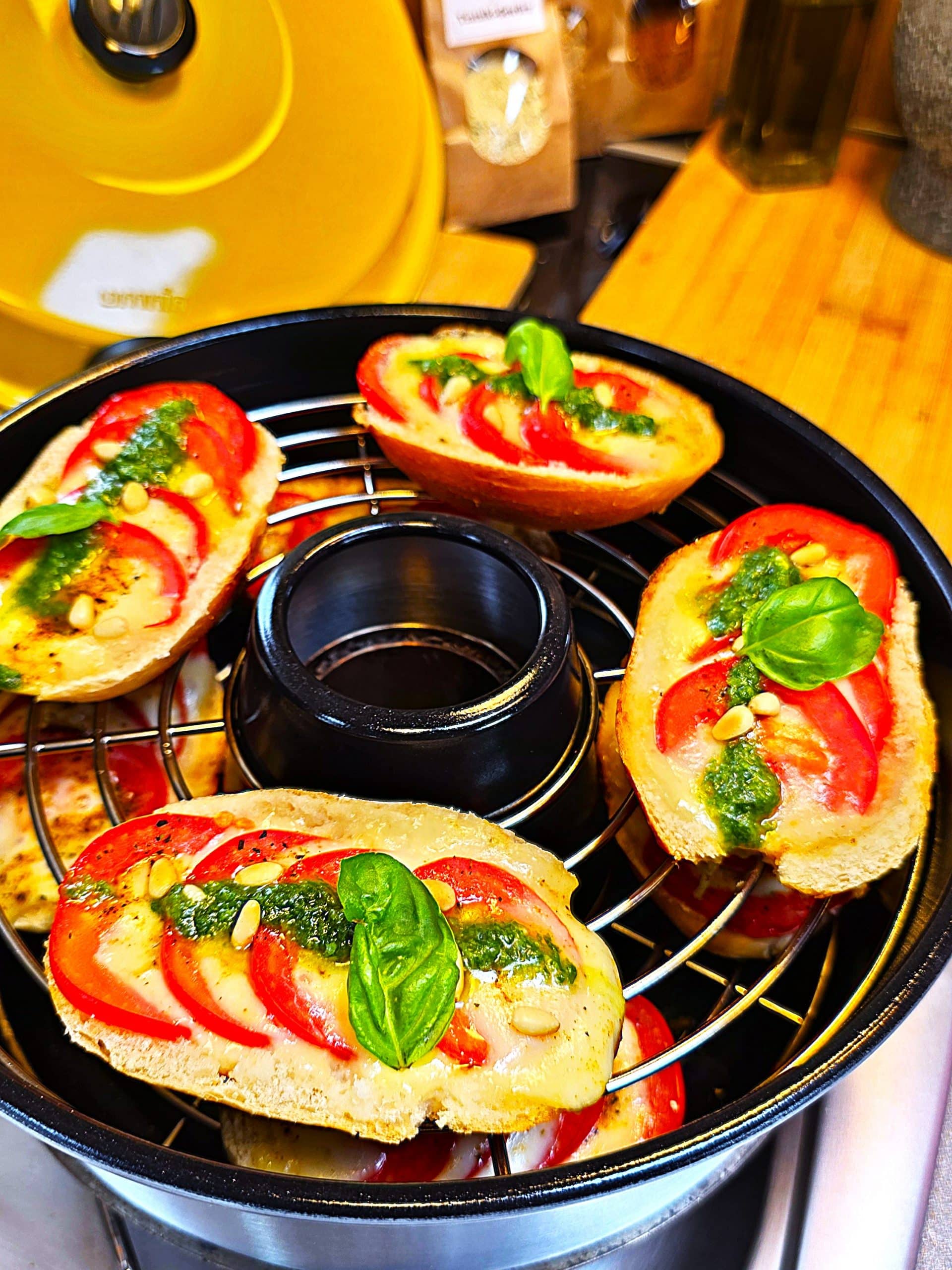 Gefülltes Baguette mit Tomaten und geschmolzenem Mozzarella im Omnia Campingbackofen auf einem Gaskocher.