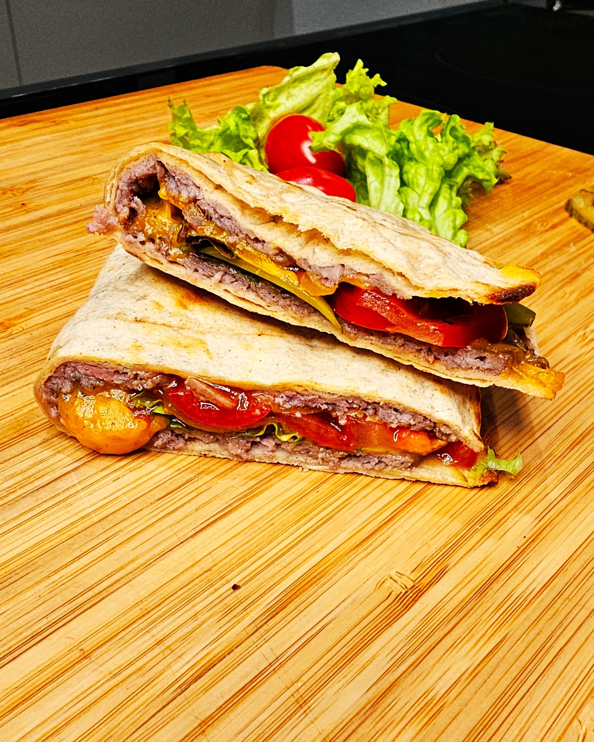 Flach gedrückter Tortilla Smash Burger mit Käse, frisch zubereitet in einem Schlitz-Toaster beim Camping.