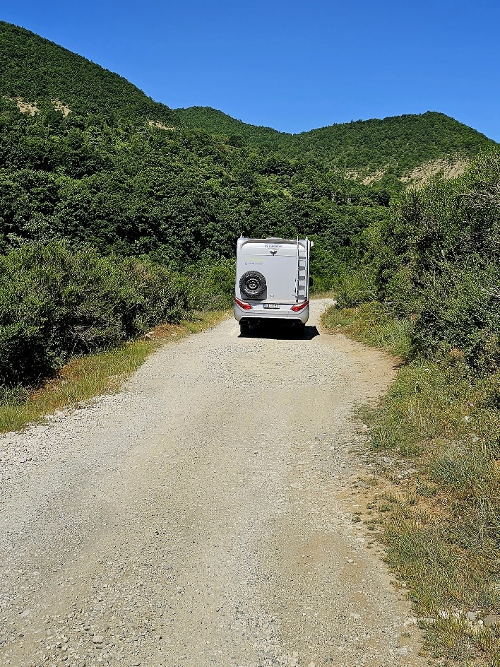Campingbus auf einem malerischen Stellplatz an der Küste während einer Reise durch Europa.