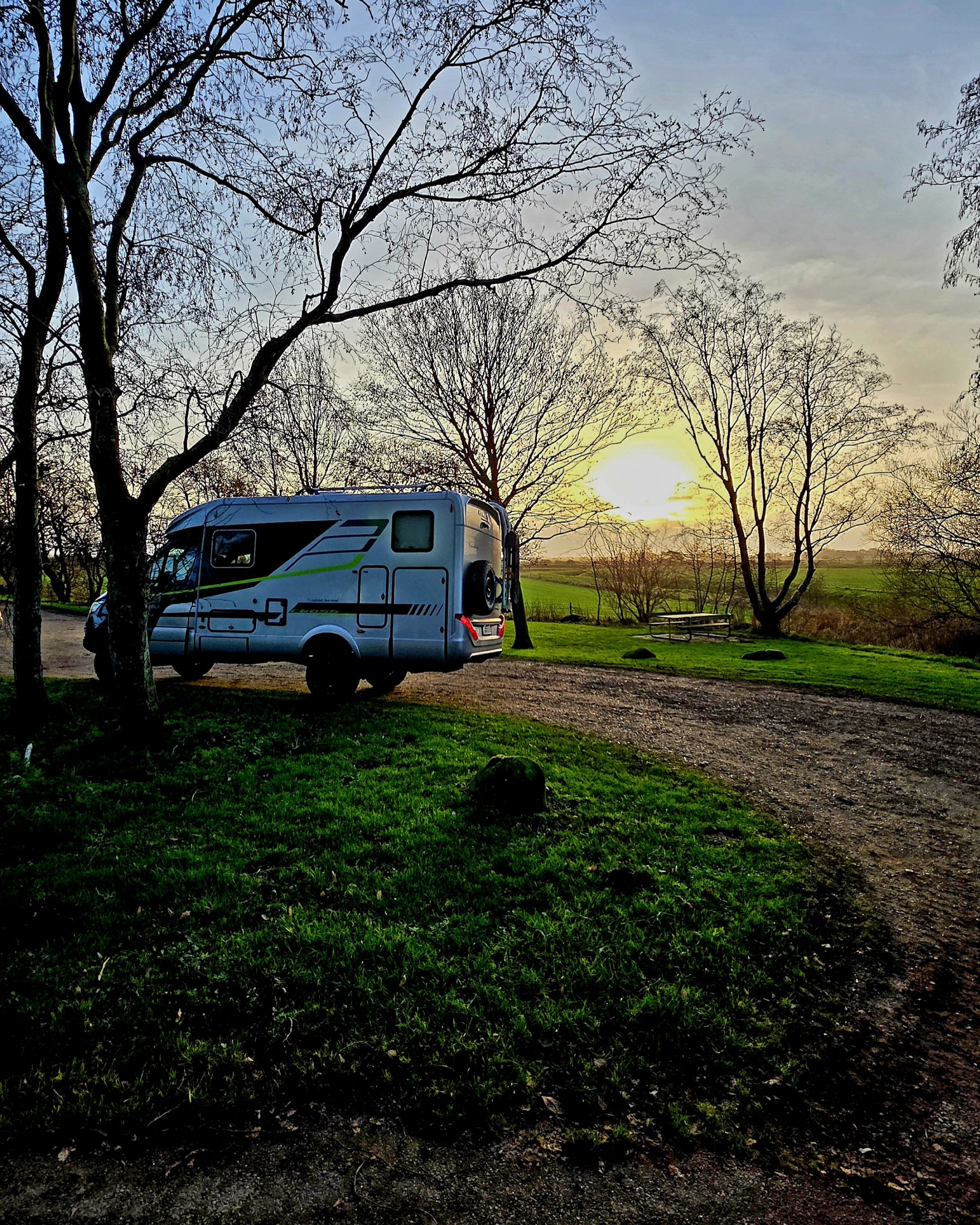 Wohnmobil auf einem winterlichen Stellplatz in Dänemark mit leichtem Schneefall