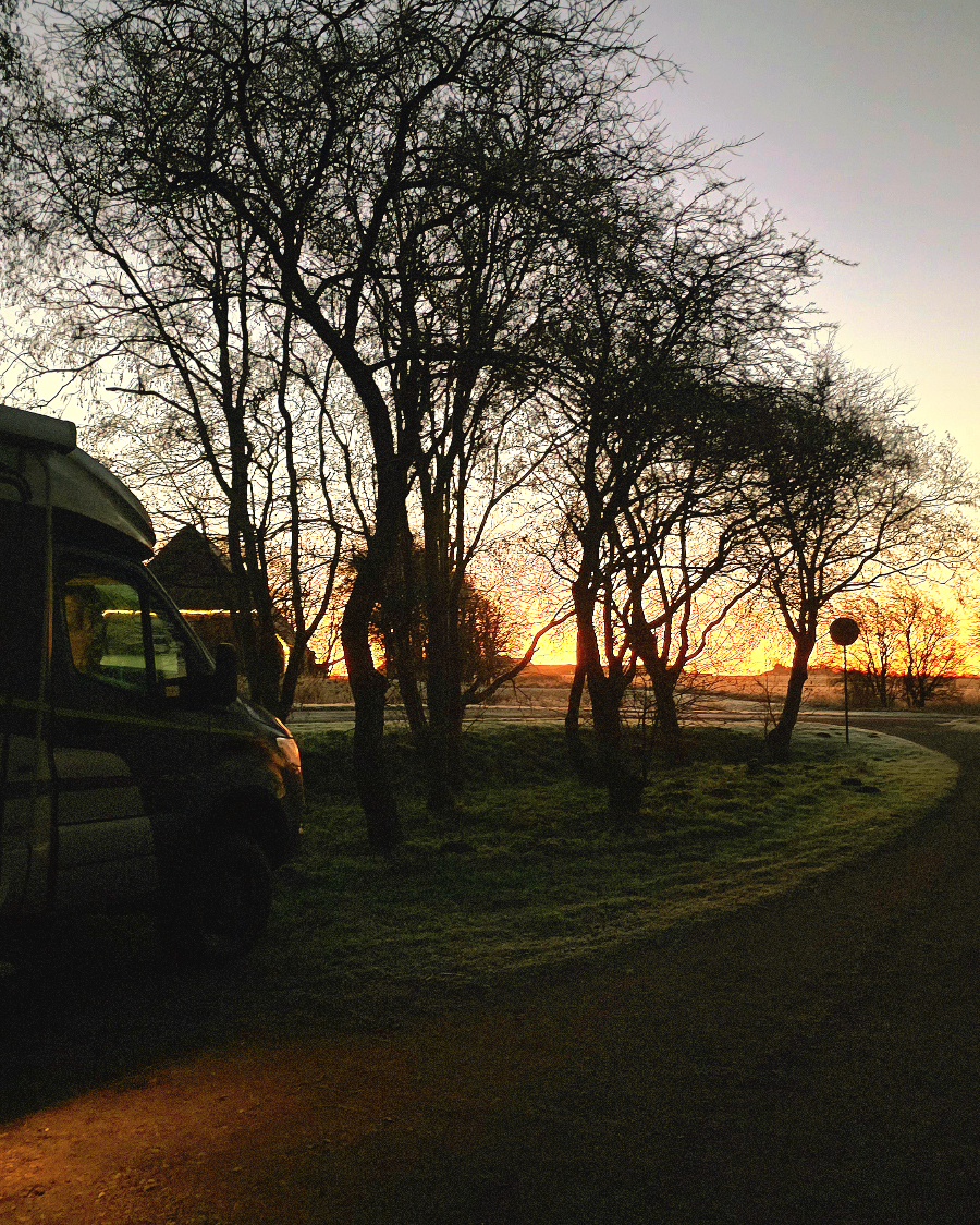 Wohnmobil auf einem winterlichen Stellplatz in Dänemark mit leichtem Schneefall